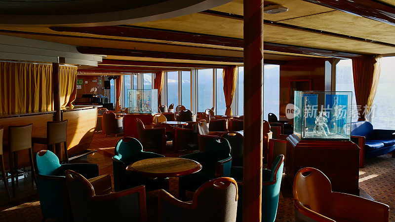 海达游轮(RoRo ferry) MS Trollfjord上的酒吧室内设计，配有桌椅和装饰。